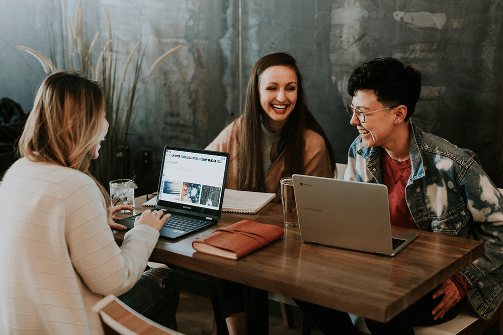 group of people at laptops smiling