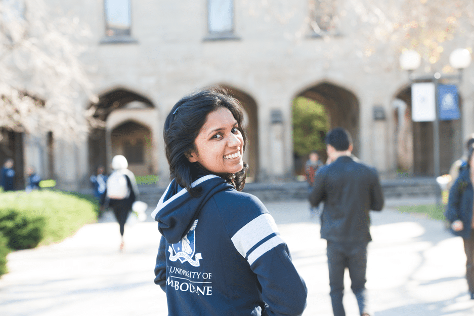 Image of a smiling student wearing a university of Melbourne hoodie